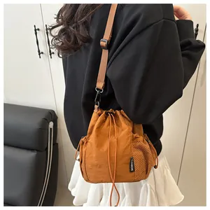 Detail der braunen Nylon-Beuteltasche mit Netz-Seitentasche und modischem Etikett