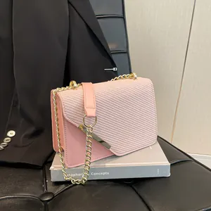 Pink chain shoulder bag with textured PU leather and golden metal clasp on book