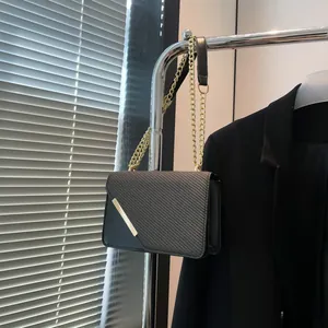 Classic black crossbody chain bag with carbon fiber texture and gold metal trim detail