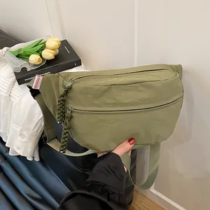 Minimalist olive green nylon crescent crossbody bag with adjustable wide strap and woven details