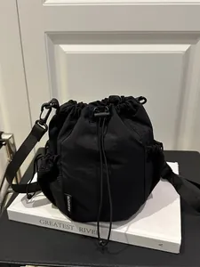 Minimalistische schwarze Nylon-Beuteltasche mit Kordelzug und seitlicher Netztasche