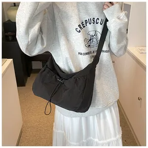 Dettaglio della borsa a mezzaluna nera con coulisse e tracolla regolabile in nylon