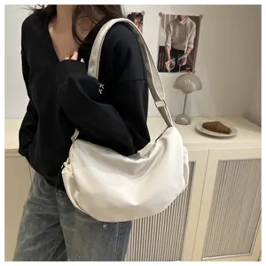 Detailed view of white nylon crescent bag showing soft fabric and silver strap buckle
