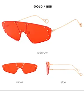 Three perspectives of gold metal frame shield sunglasses with red lenses and gold rivets