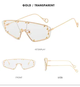 Detail view of gold metal sunglasses with transparent shield lenses and rivet accents