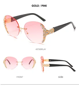Detail view of gold-rimmed oversized pink gradient sunglasses with rhinestone accents