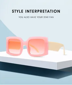 Detail of square sunglasses with pink frame, orange gradient lenses on white stand