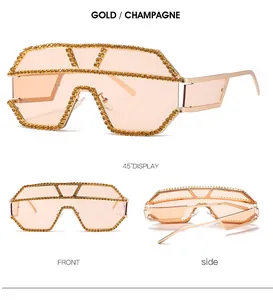 Viste dettagliate degli occhiali da sole oversize dorati con lussuosi strass incastonati