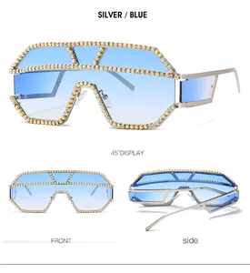 Dettaglio occhiali da sole argento oversize con strass colorati e lenti sfumate blu