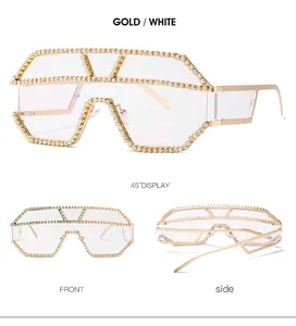 Viste dettagliate di occhiali da sole dorati oversize con montatura in metallo e strass