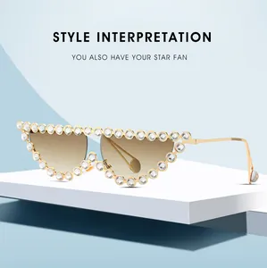 Detail of luxury cat-eye sunglasses with gold frame and large rhinestones around lenses
