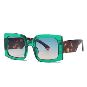 Fashionable square sunglasses with transparent green frames and gradient blue lenses