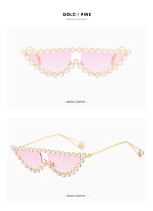 Close-up of gold metal cat-eye sunglasses with luxury rhinestones and pink gradient lenses