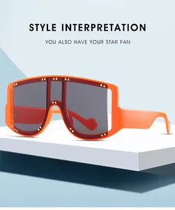 Detail of oversized orange rim sunglasses with tinted shield lens and gold stud accents