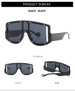 Detail of oversized black sunglasses featuring gold rivet accents on the frame