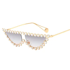 Cat eye sunglasses with gold metal frame and sparkling rhinestones on grey gradient lenses