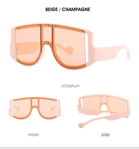 Detail view of oversized beige shield sunglasses with gold studs and champagne lenses