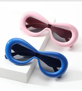 Close-up of thick oval frame sunglasses in vibrant pink and bold blue colors