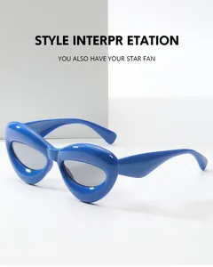 Dettaglio degli occhiali da sole geometrici blu brillante con lenti grigio scuro