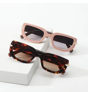 Detailed close-up of geometric sunglasses with gold arrow hinges and matte finish