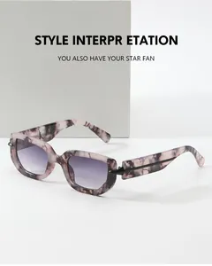 Detail of pink marble textured sunglasses frame with purple gradient lenses and black trim