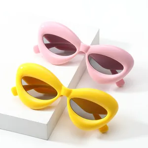 Occhiali da sole alla moda con montatura spessa rosa e gialla opaca su basi di pietra