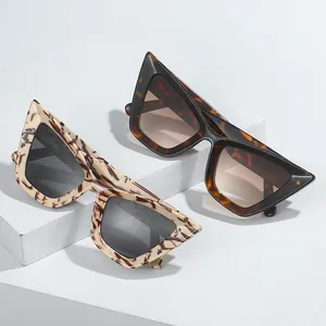 Lunettes de soleil œil de chat à motif écaille sur des supports géométriques blancs