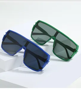Dettaglio degli occhiali da sole shield oversize nei colori blu e verde