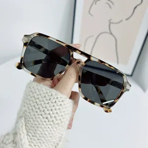 Detailed close-up of tortoise shell square frame sunglasses with dark gray lenses