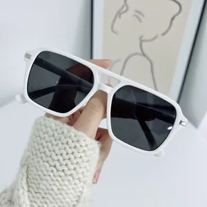 Close-up of square white sunglasses with dark lenses and silver metal corner details