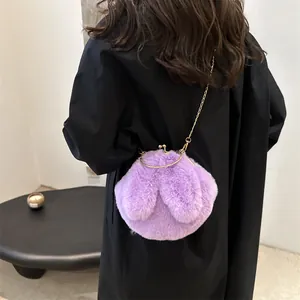 Paarse pluche hobo tas met konijnenoren en gouden ketting gedragen door een model