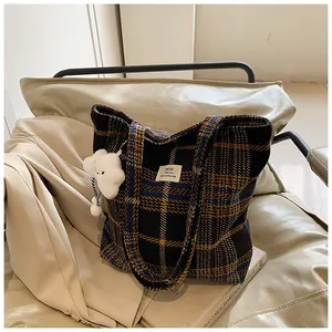 Dettaglio di una grande borsa tote scozzese in lana con un ciondolo a forma di nuvola bianca