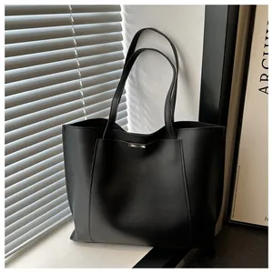 Détail d'un sac cabas noir minimaliste en similicuir lisse avec une boucle métallique