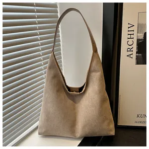 Dettaglio ravvicinato della borsa tote grande in camoscio kaki con chiusura magnetica in metallo