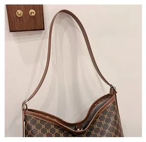 Detail of vintage brown tote bag with classic monogram pattern and leather trim