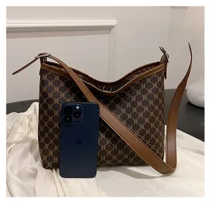 Detailed size comparison of the brown tote bag with a smartphone to show capacity