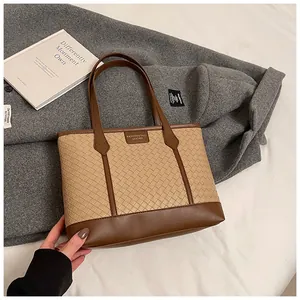 Détail de la texture en cuir tissé et étiquette mode sur le sac cabas beige et marron
