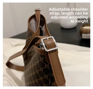 Close-up of adjustable brown leather shoulder strap with silver buckle on tote bag