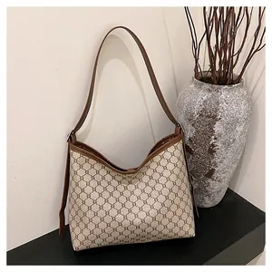 Close-up of retro beige tote bag with brown geometric pattern and leather strap