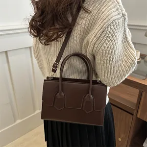 Dark brown leather tote bag for women featuring long straps and minimalist vintage design