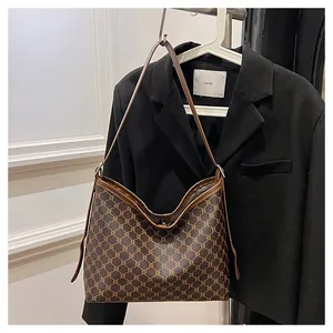 Detail view of the vintage brown geometric pattern and premium leather strap on a hobo bag