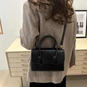 Minimalist black structured tote bag for women with dual handles and slender shoulder strap