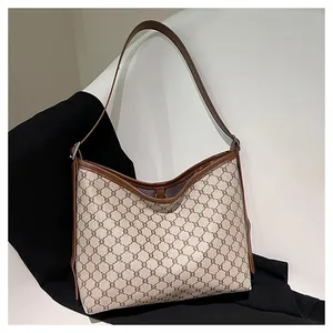 Detail of vintage monogram hobo tote bag with brown leather handle and curved opening
