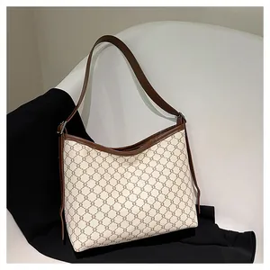 Detail of vintage tote bag featuring retro pattern and brown leather adjustable strap