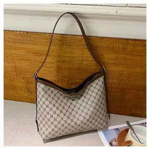 Macro shot of vintage brown monogram pattern tote bag with leather straps and classic trim