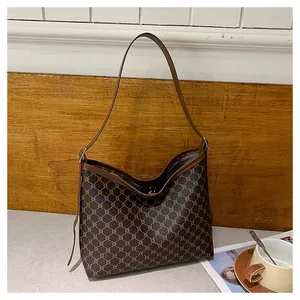 Close-up of vintage brown tote bag with geometric pattern and slim leather shoulder strap