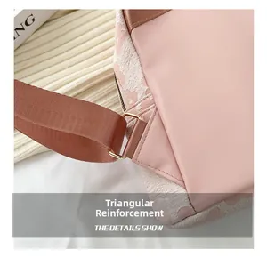 Detail der rosa Canvas-Tasche mit Dreiecksverstärkung und goldenen Metallbeschlägen