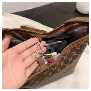 Interior view of brown monogram tote bag showing spacious capacity and metal clasp detail