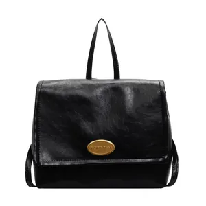 Retro black leather backpack with gold buckle and top handle in a minimalist style