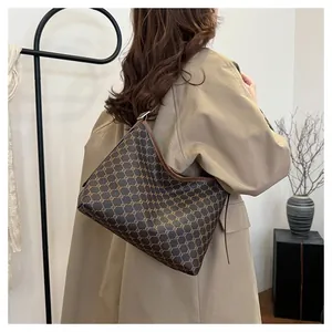 Brown monogram tote bag styled with a khaki trench coat for a classic autumn look